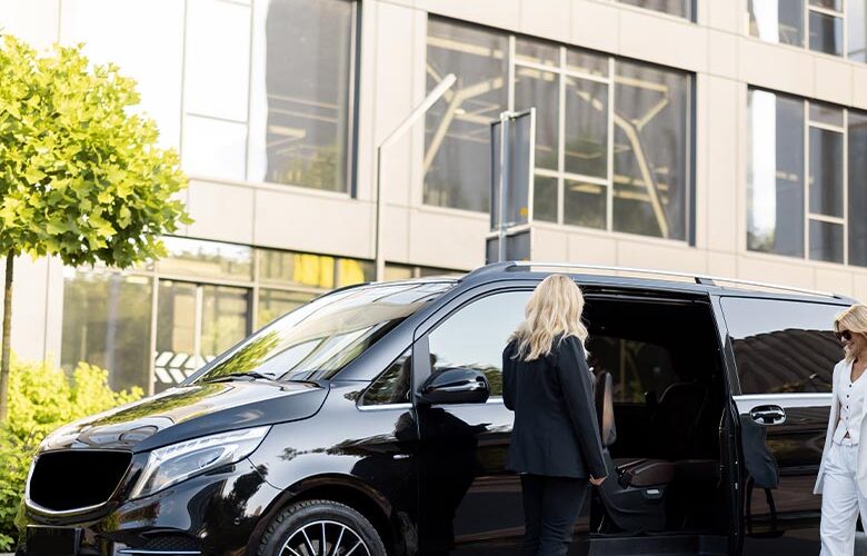 A black Mercedes-Benz V-Class people carrier parked outside a modern office